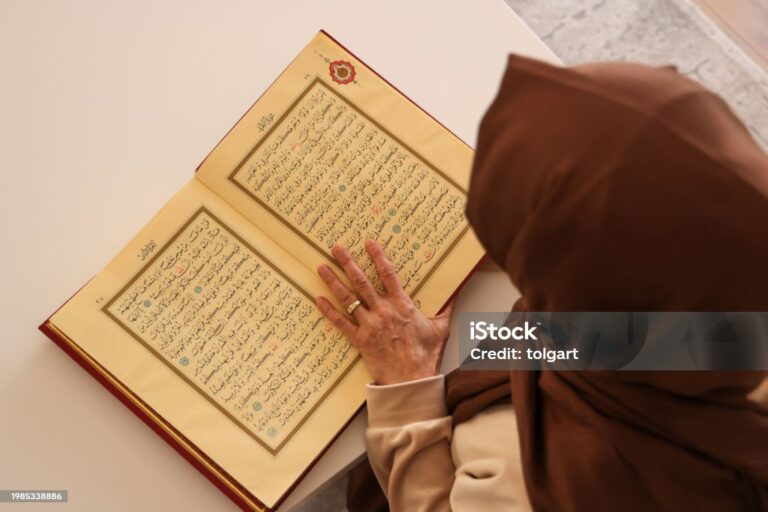 Senior muslim woman reading Quran at home