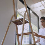Asian young man is measuring a window to install curtains. DIY.