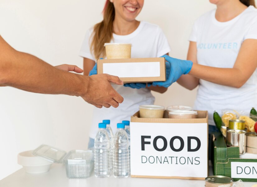 smiley-volunteers-with-gloves-handing-boxes-with-food-donation_23-2148733763