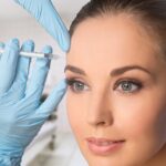 Professional doctor injecting Botox in female patient's facial skin
