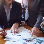 business-people-meeting-using-calculator-notebook-stock-market-chart-paper-for-analysis-plans