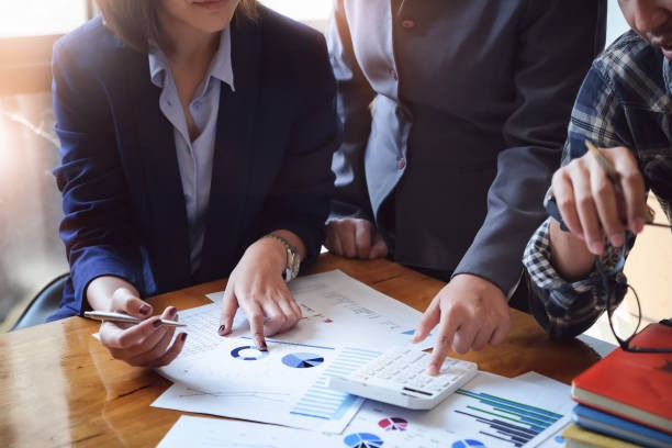 business-people-meeting-using-calculator-notebook-stock-market-chart-paper-for-analysis-plans