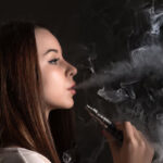 face-vaping-young-woman-black-studio_155003-1831