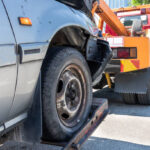 Tow truck towing a broken down car in emergency on the street