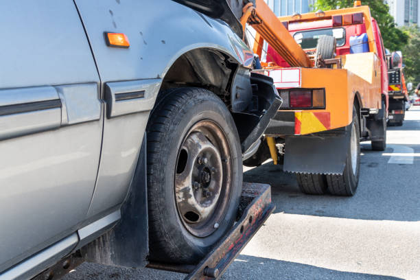 Tow truck towing a broken down car in emergency on the street