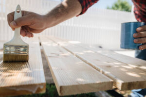 Applying protective varnish on a wooden boards.