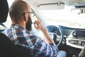 man smoking a vape in a car