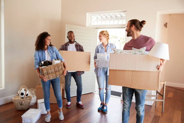 Friends Help Couple To Carry Boxes Into New Home On Moving Day