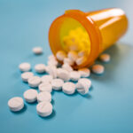 Pile of white pills on blue background