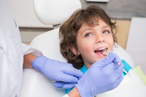 Pediatric,Dentist,Examining,A,Little,Boys,Teeth,In,The,Dentists