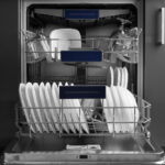 An open dishwasher with plates and glasses