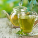 Herbal tea in class teapot and cup