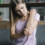 portrait-sick-young-woman-touching-her-elbow (1)
