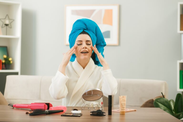 with-closed-eyes-young-girl-wrapped-hair-towel-applying-tone-up-cream-sitting-table-with-makeup-tools-living-room (1)