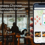 Smartphone displaying ‘restaurants near me’ search results on a map inside a busy restaurant, illustrating local SEO services for restaurants.