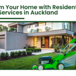 Residential lawn mowing service in Auckland with professional gardener mowing grass outside a modern home garden