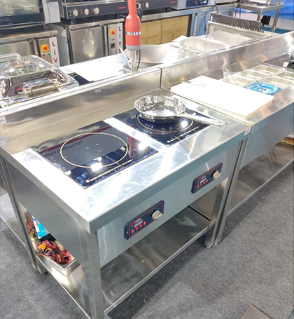 Free standing induction cooking station with dual induction burners in commercial kitchen setup
