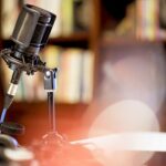 Microphone in a studio surrounded by equipment under the lights with a blurry background