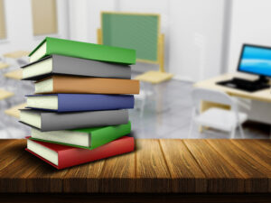 Wooden table and books with defocussed classroom image