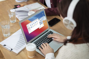 girl-with-headphones-using-laptop-along-her-classmates-group-study