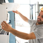 Technician cleaning air conditioner filter