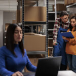 Retail storehouse employees checking clipboard with orders list