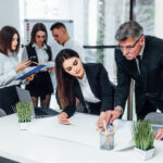Young business people painting and writing at the modern office space.