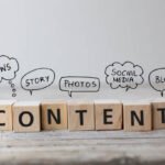 Wooden blocks spelling CONTENT with speech bubbles illustrating key content marketing strategies like news, stories, photos, social media, and blogs.