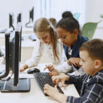 Children sit at computers in the classroom.