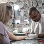 Tattoo artist preparing to tattoo a woman at a tattoo studio