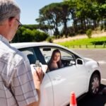 Learner driver girl with intstructor taking lessons