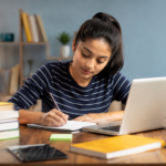 Do My Assignment – student working on an academic assignment with laptop and books