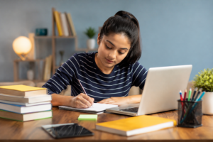 Do My Assignment – student working on an academic assignment with laptop and books