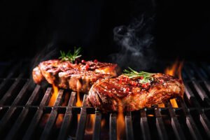 Beef steaks on the grill with flames