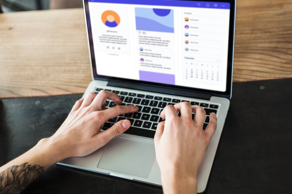 A person typing on a laptop keyboard with a digital marketing dashboard and social media analytics displayed on the screen.