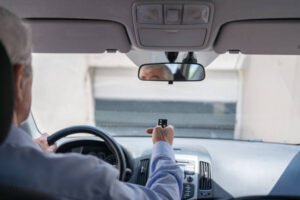 Man In Car Using Remote Control To Open The Automatic Garage Door