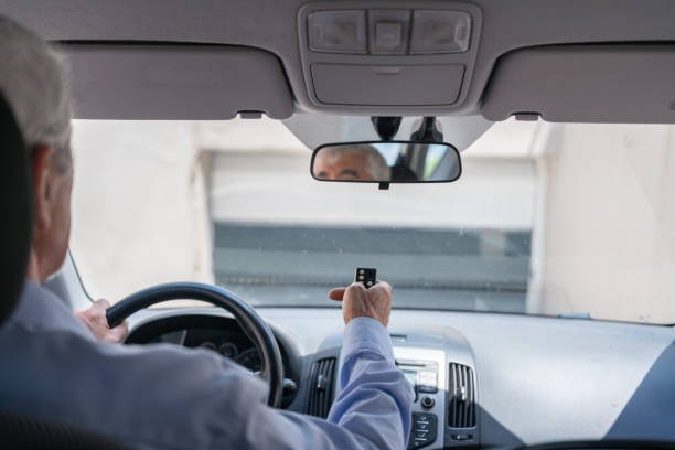Man In Car Using Remote Control To Open The Automatic Garage Door